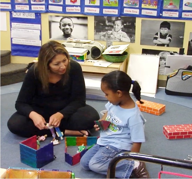 Classroom video still published by Teachstone showing an educator and children sharing an activity