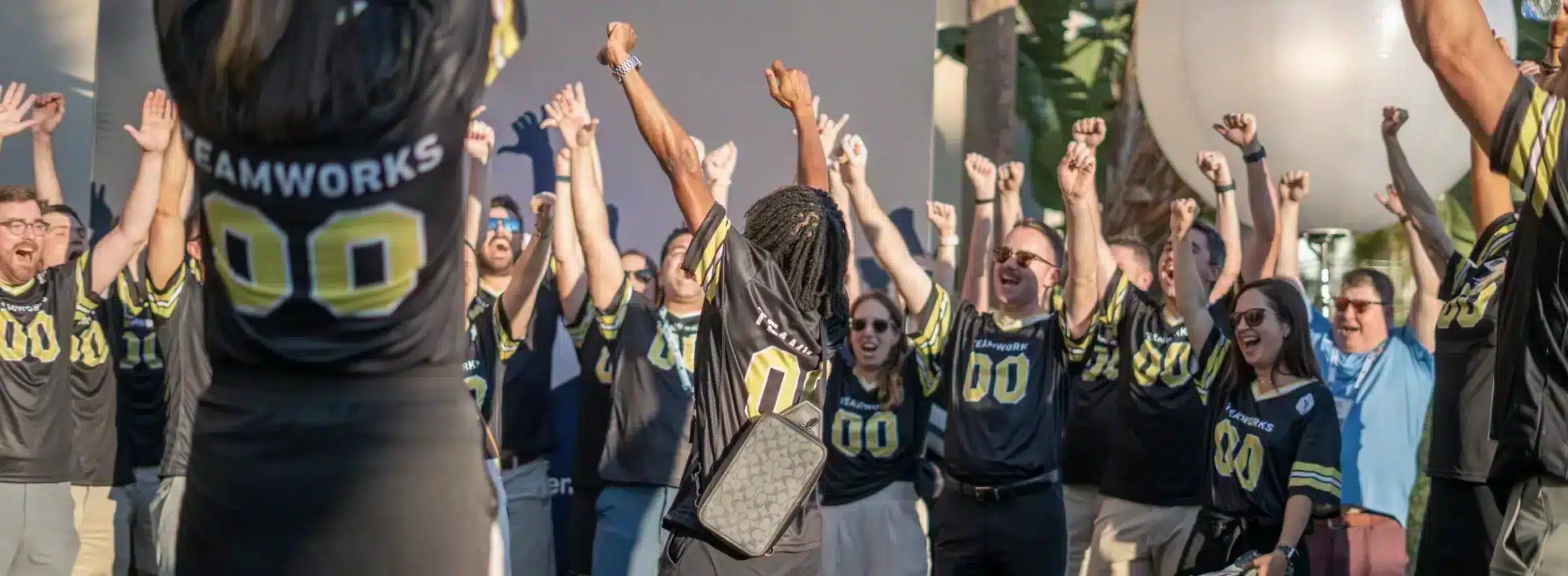 Teamworks employees in matching jerseys celebrating at the 2023 NACDA event