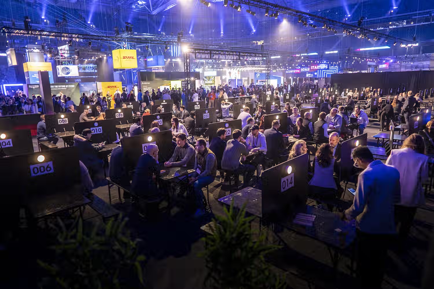 Rows of numbered meeting tables filled with attendees on TECHARENA’s arena floor