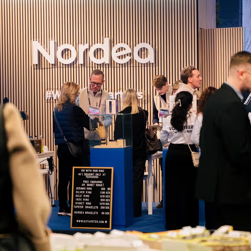 Visitors talking beside Nordea’s exhibition stand at TECHARENA 2026