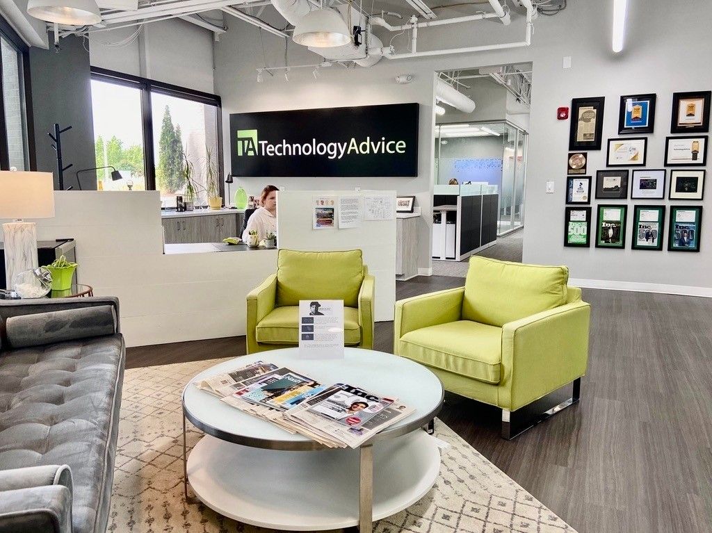 TechnologyAdvice's Nashville office lobby with green chairs and the company wordmark on the wall