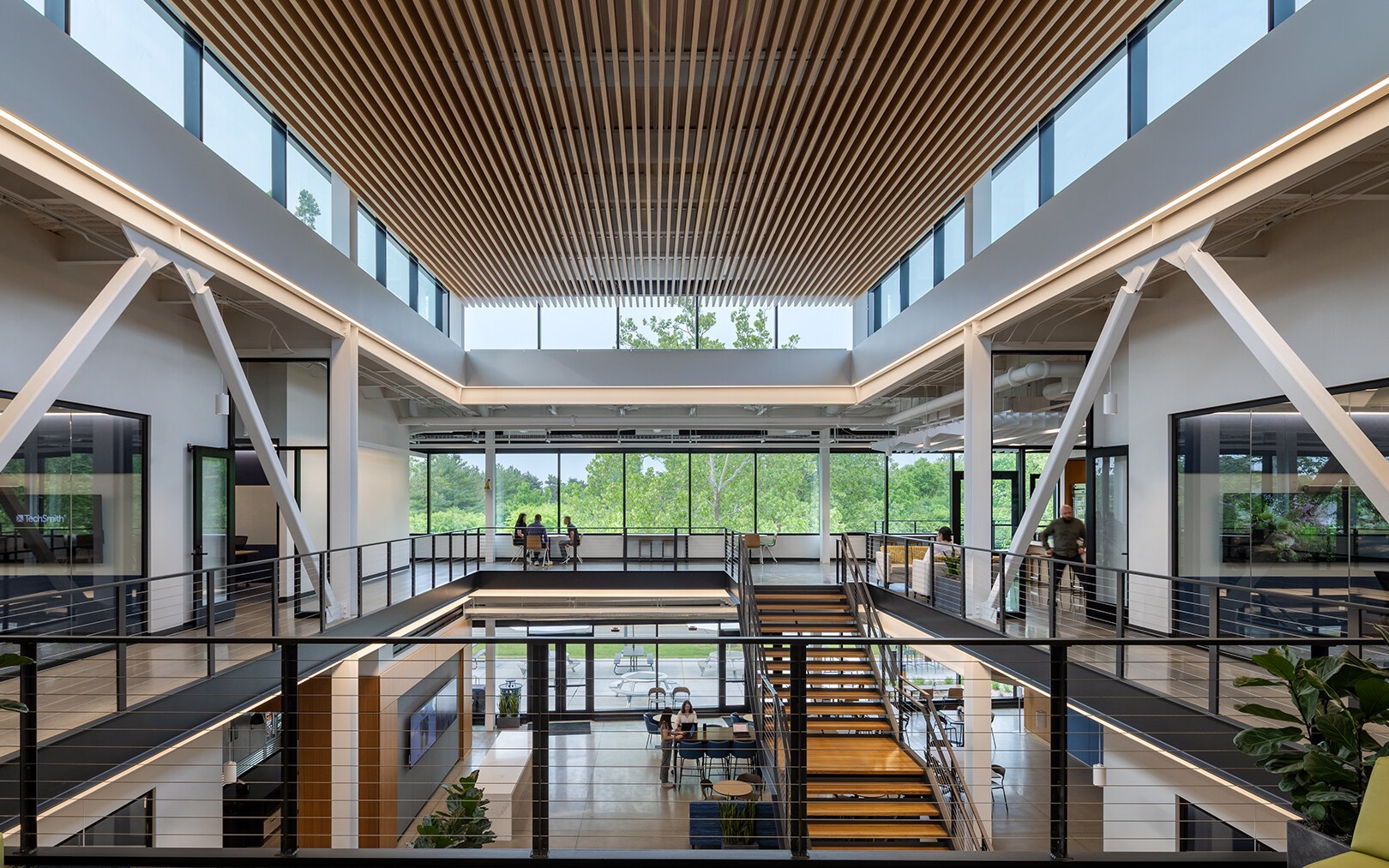 Daylit interior of TechSmith’s headquarters with communal seating and a staircase