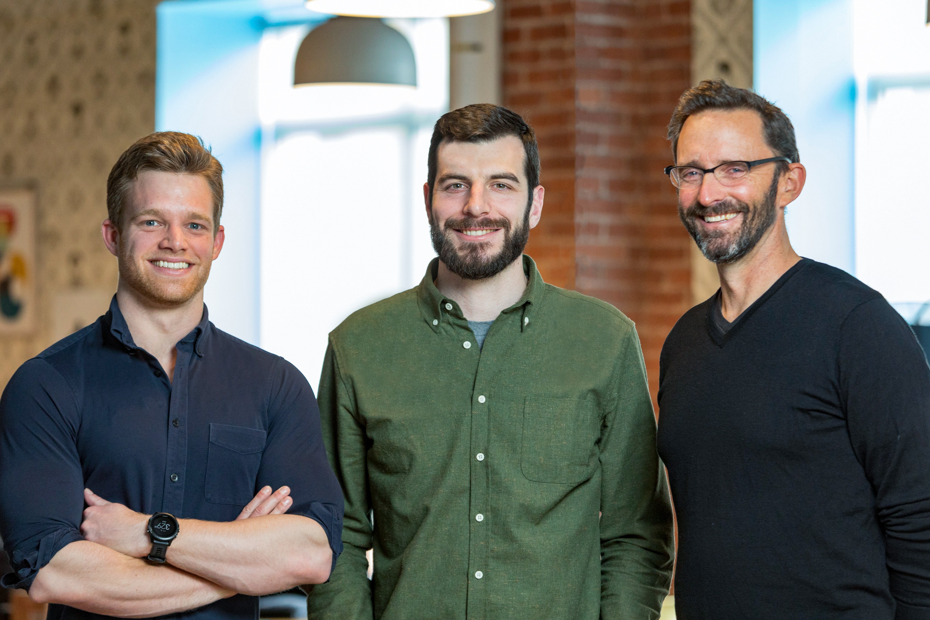 Tecton founders Mike Del Balso, Kevin Stumpf, and Jeremy Hermann standing together in an office