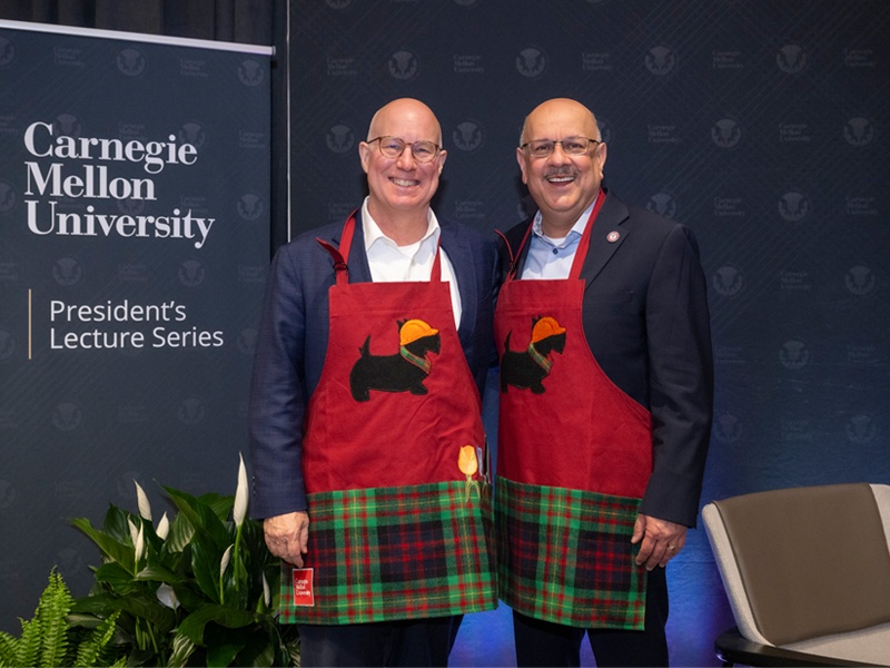 Ted Decker and Carnegie Mellon president Farnam Jahanian wearing red university-themed work aprons