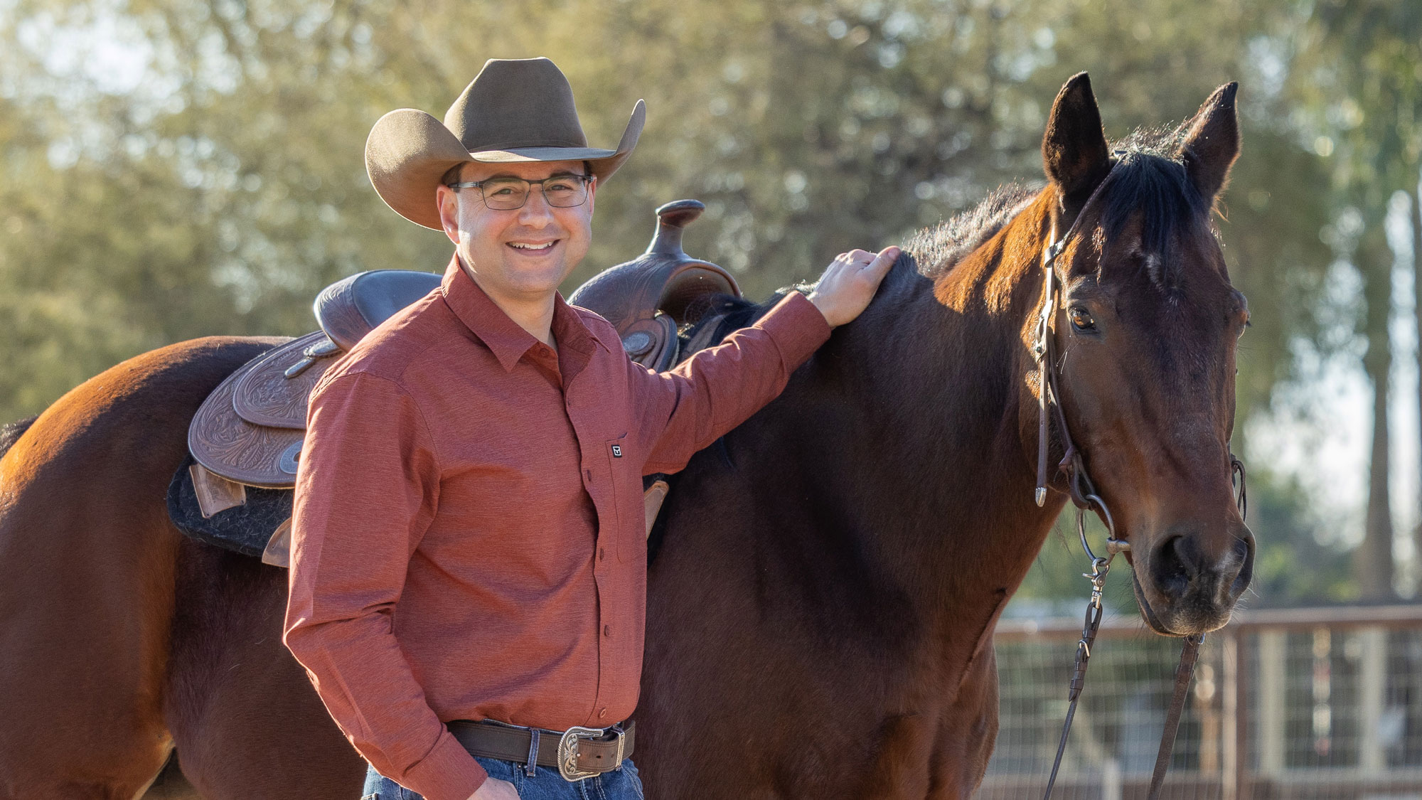 Ted Geisler in a cowboy hat beside Scoot, a quarter-horse, at Hunkapi Farms in Scottsdale