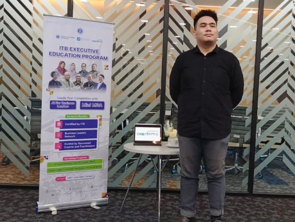 Teguh Eko Budiarto standing beside an ITB Executive Education Program display
