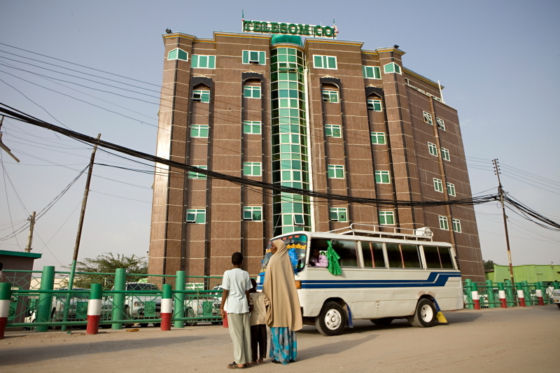 Archival street photograph of a building bearing Telesom signage in Hargeisa, with a minibus outside