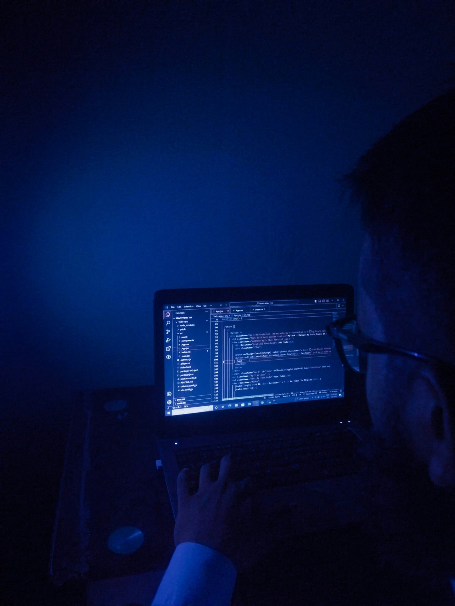 A Tellagence team member working at a computer in blue light