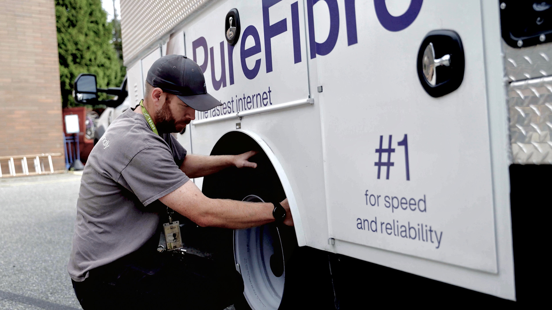 A TELUS field technician working beside a PureFibre service truck