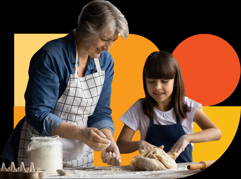 An older woman and a young girl baking together against Tenure Health's colorful shapes