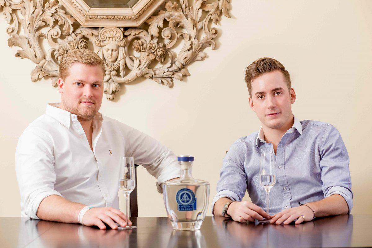 Tequila Enemigo co-founders Max Davies-Gilbert and Robin Clough seated with a bottle of Enemigo 89