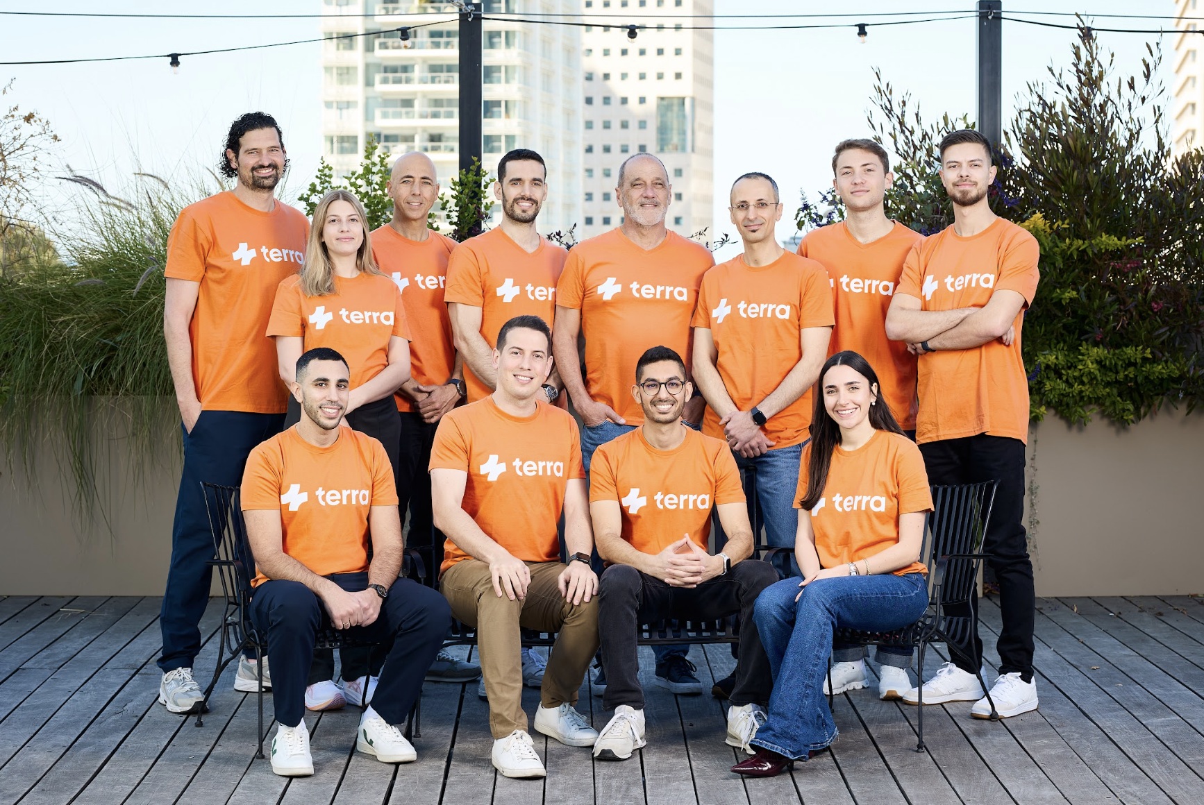 Terra team members wearing orange company shirts on an outdoor terrace