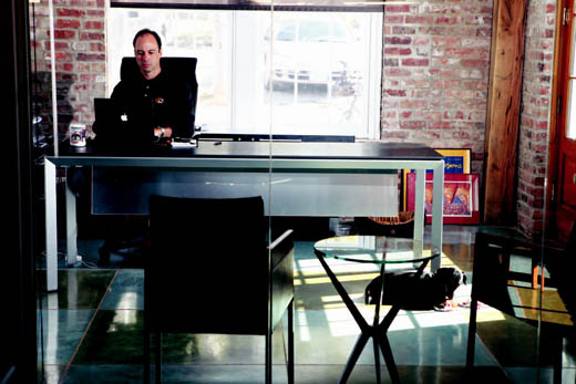 Terry Woodruff at work in his office while his dog Nemo plays nearby