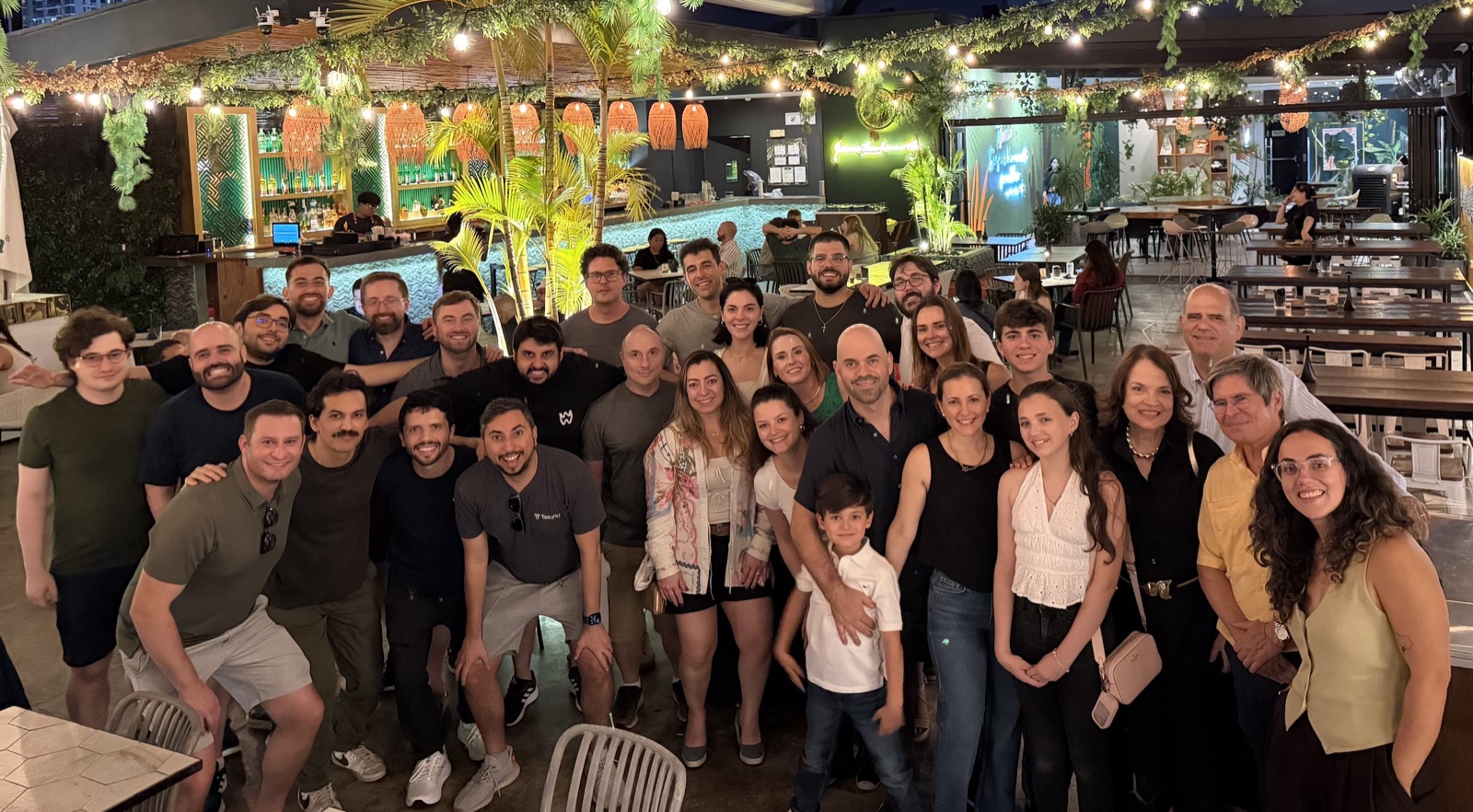 Tesorio team members gathered for a group photograph in a plant-filled venue