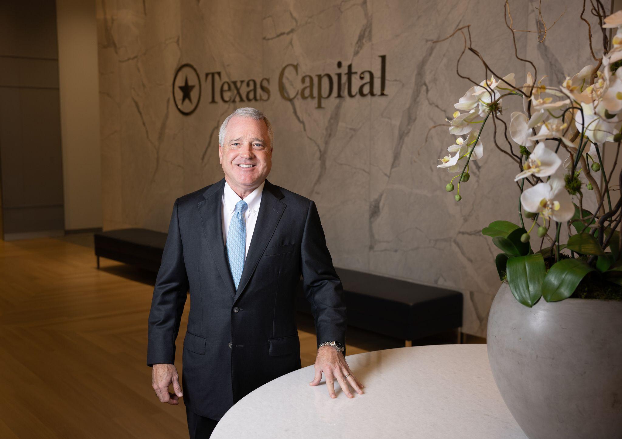 Rob C. Holmes standing beside a table in Texas Capital’s Dallas headquarters lobby