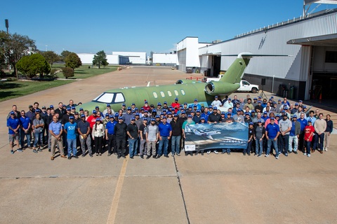 Textron Aviation manufacturing employees gather around a green, unpainted Citation CJ4 Gen3 outside the Wichita factory
