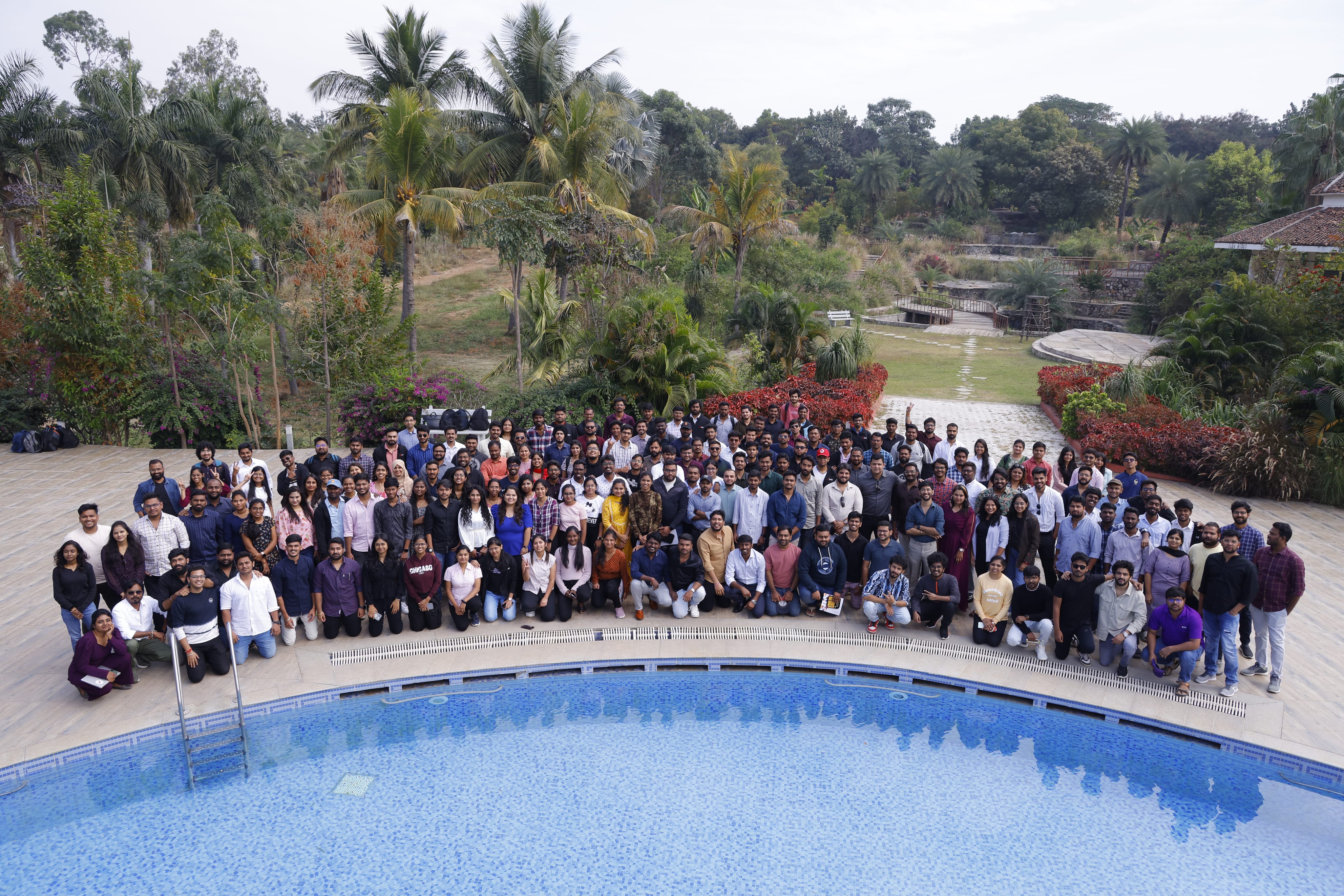 A large group pictured outdoors beside a swimming pool on Tezo’s About page