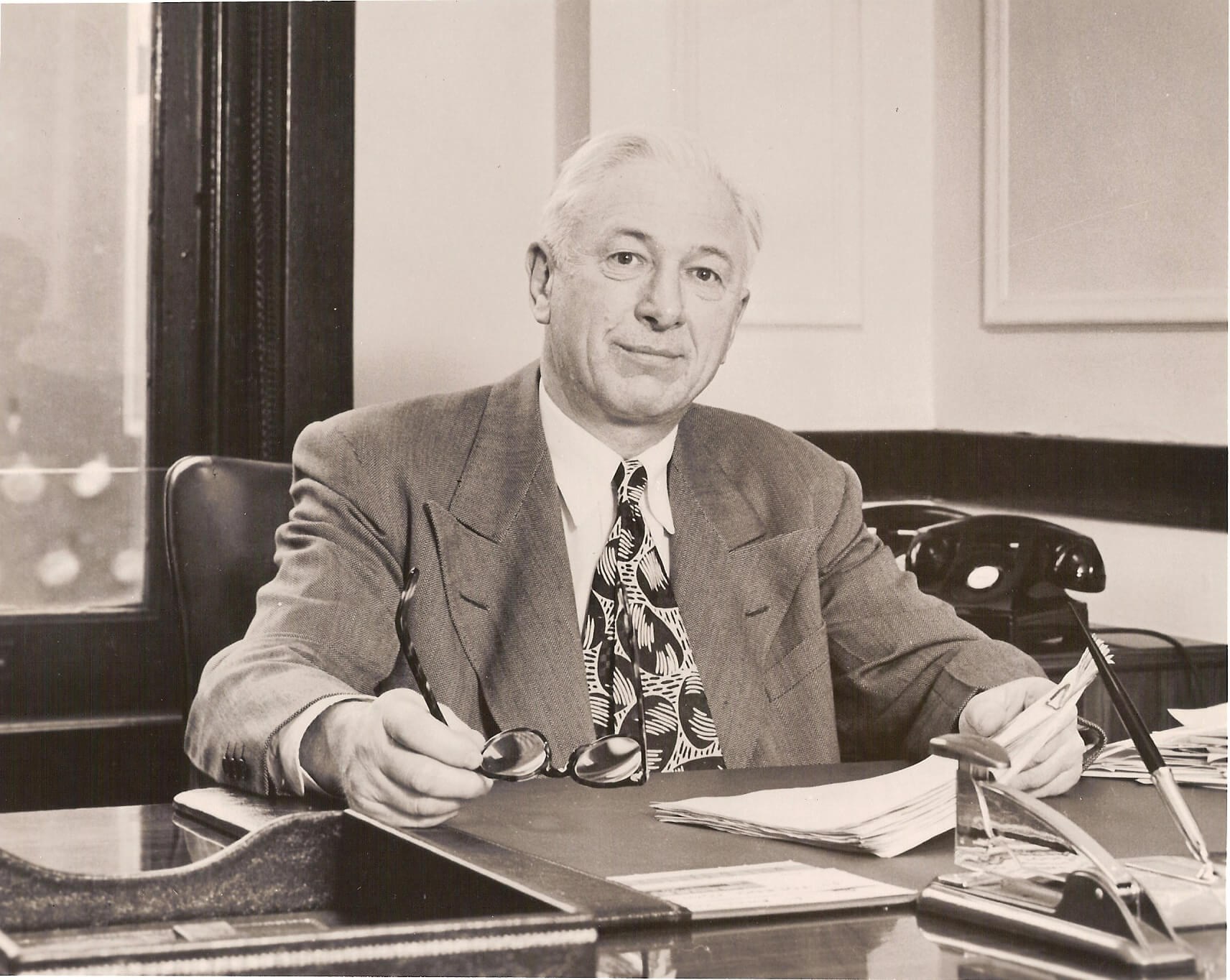 Archival photograph of co-founder Harold Anderson seated at his desk