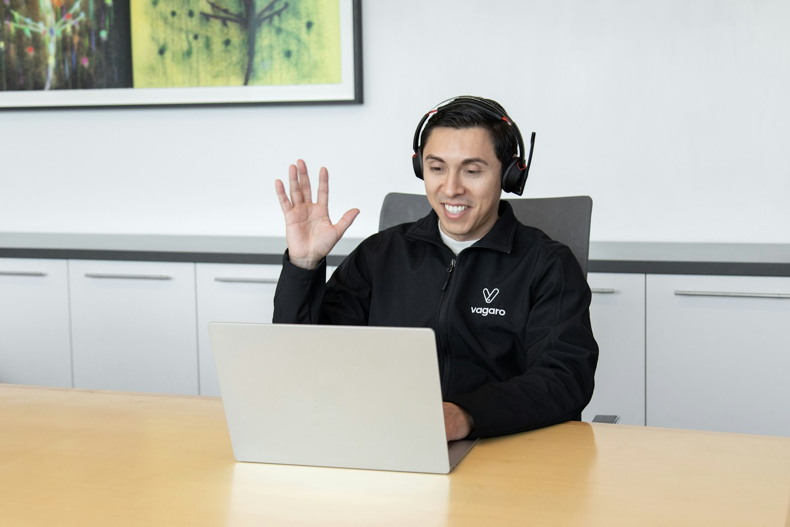A customer service agent wearing a headset at a laptop