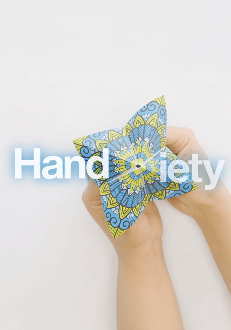 Handxiety campaign image showing hands holding a patterned paper fortune teller