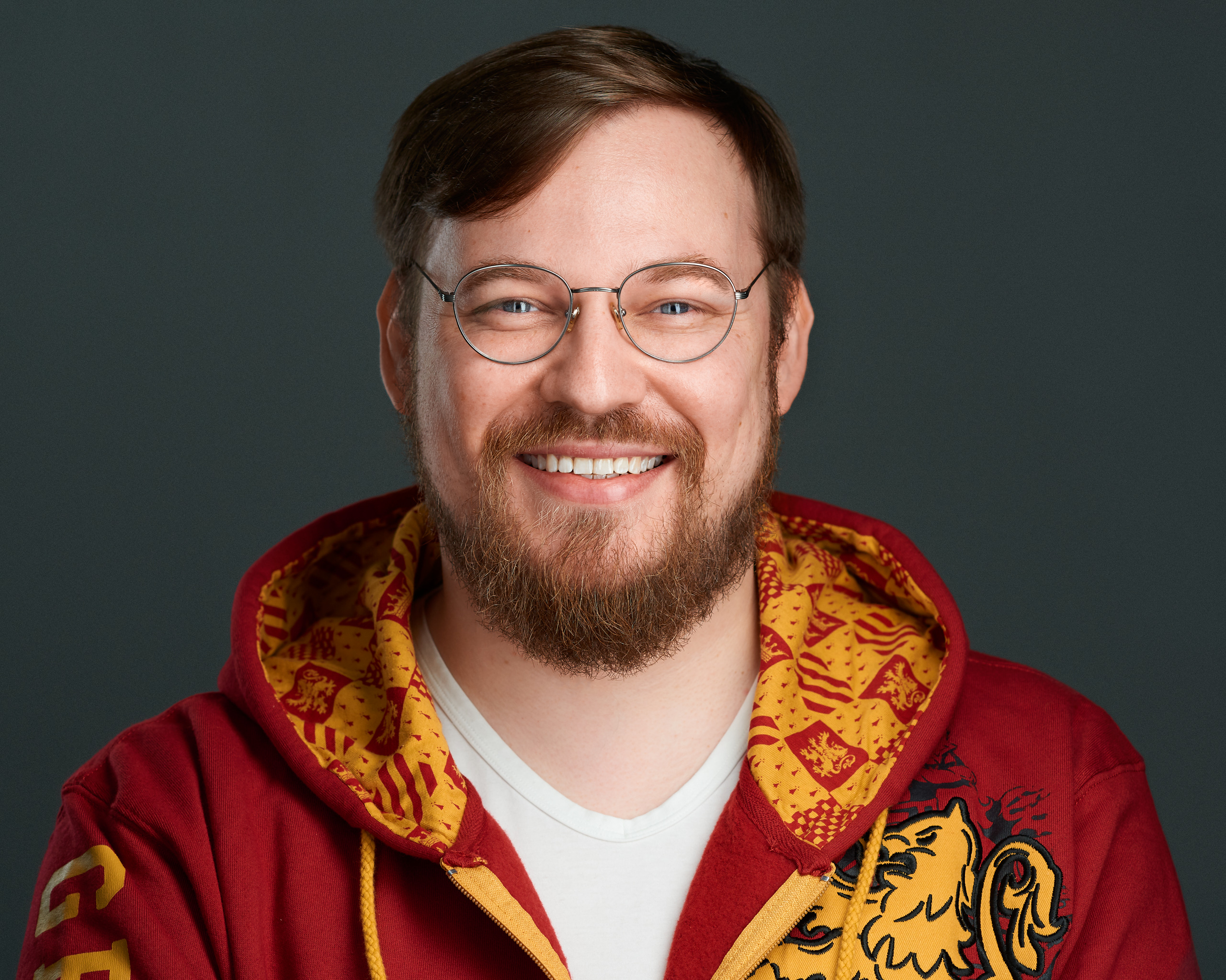 Arvid Kahl wearing glasses and a red and yellow patterned hoodie