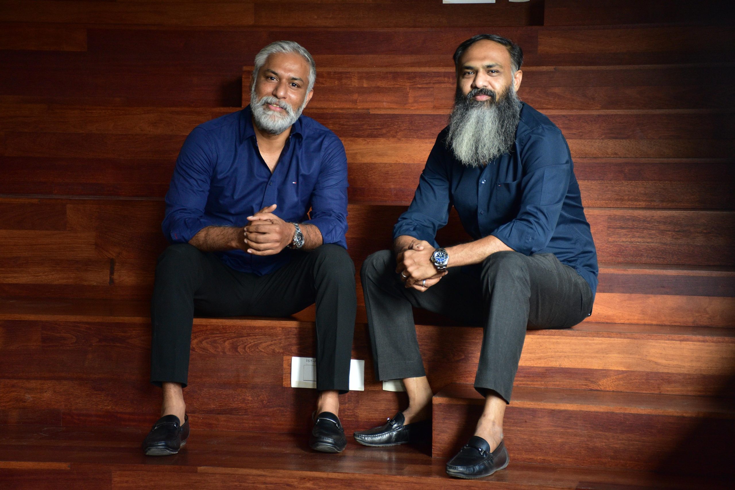 Chai Kings founders Balaji Sadagopan and Jahabar Sadique seated on wooden steps
