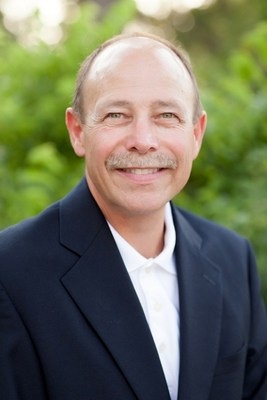 Mike Bidwell in a suit, pictured in Dwyer Group’s 2015 acquisition announcement