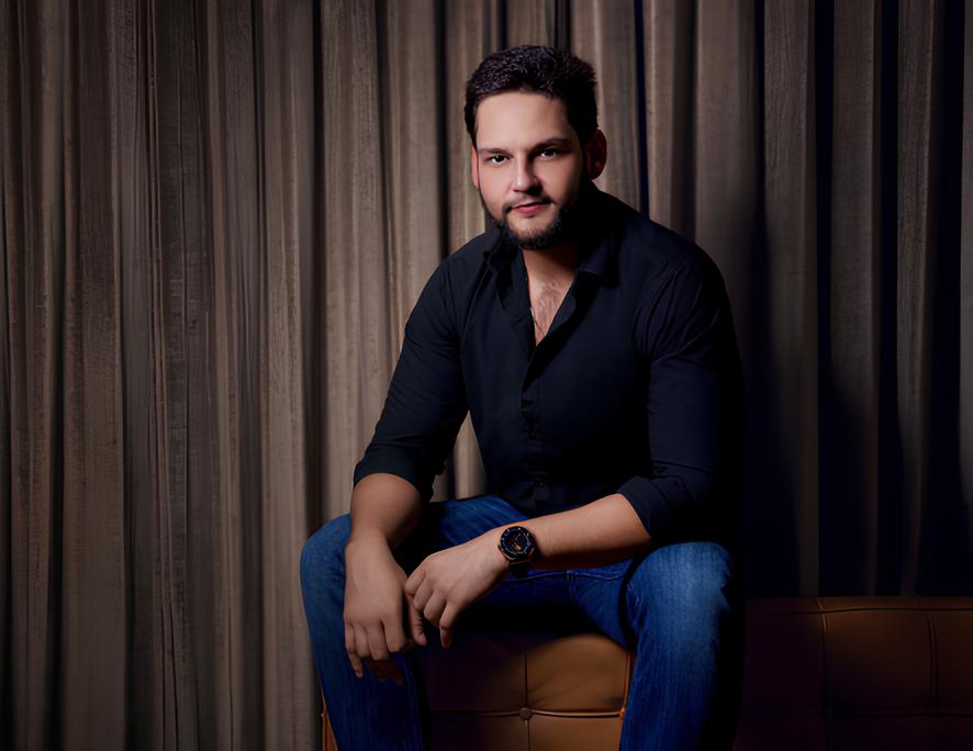 Alesh Ancira seated in a dark shirt in the agency’s founder portrait