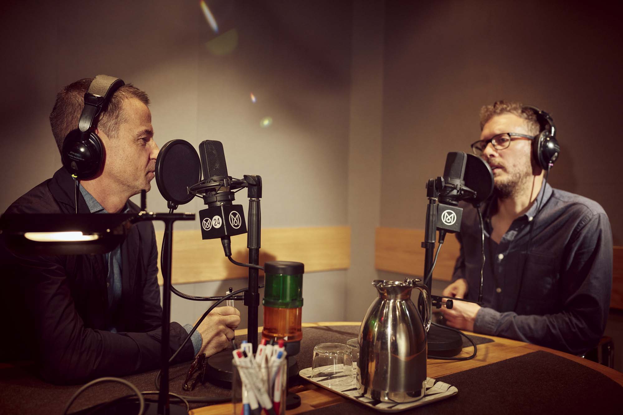 Andrew Tuck and Tom Edwards speaking across microphones in a Monocle radio studio
