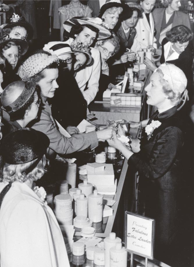 Estée Lauder demonstrating products to a crowd at a department-store beauty counter