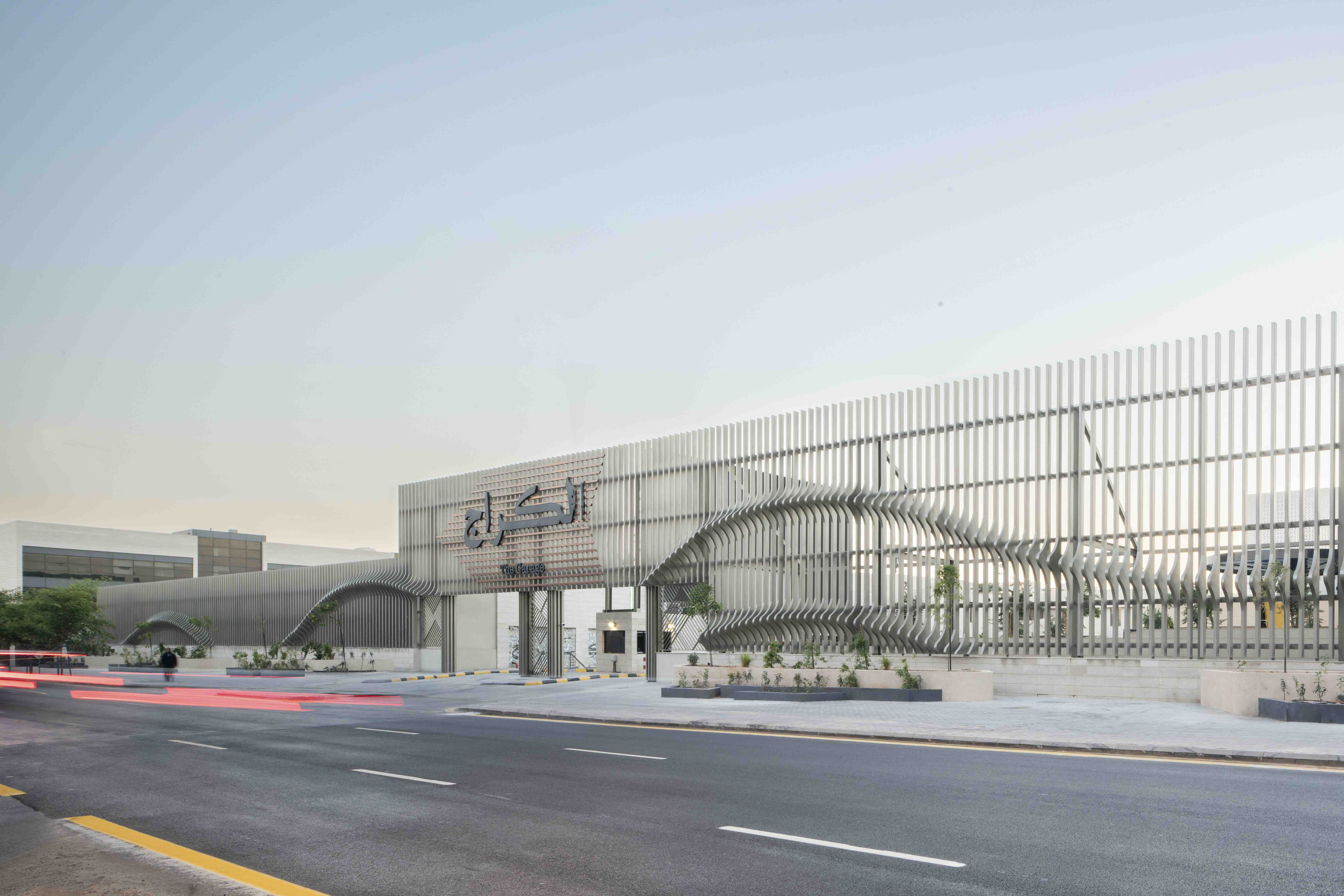 The Garage exterior in Riyadh, with curved metal fins and bilingual signage above the entrance