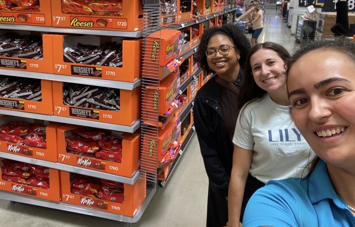 Hershey team members beside an in-store Halloween candy display