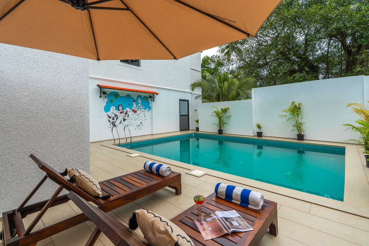 Pool and shaded wooden loungers at The Hosteller Bam Goa, Calangute