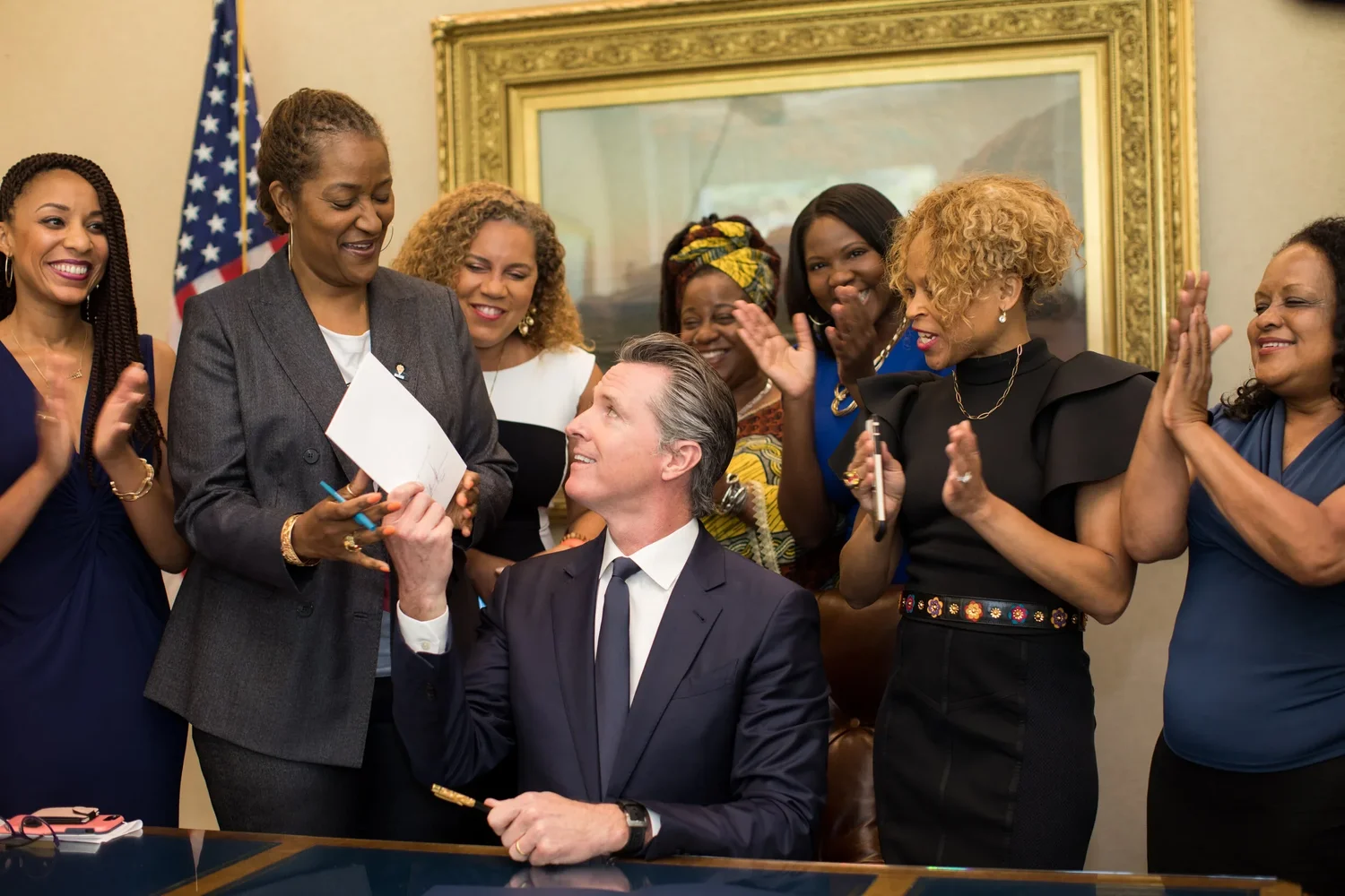 The 2019 signing of California's CROWN Act surrounded by supporters