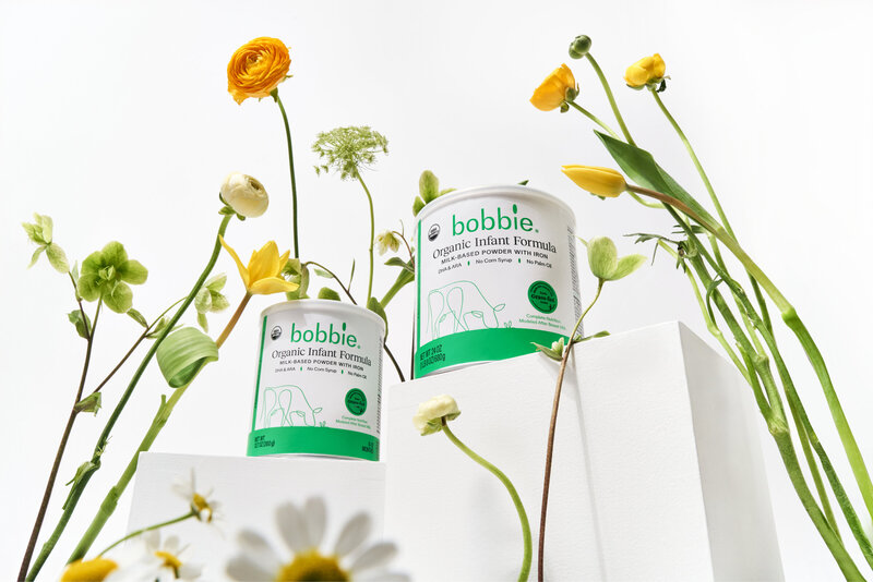 Bobbie formula containers arranged among flowers