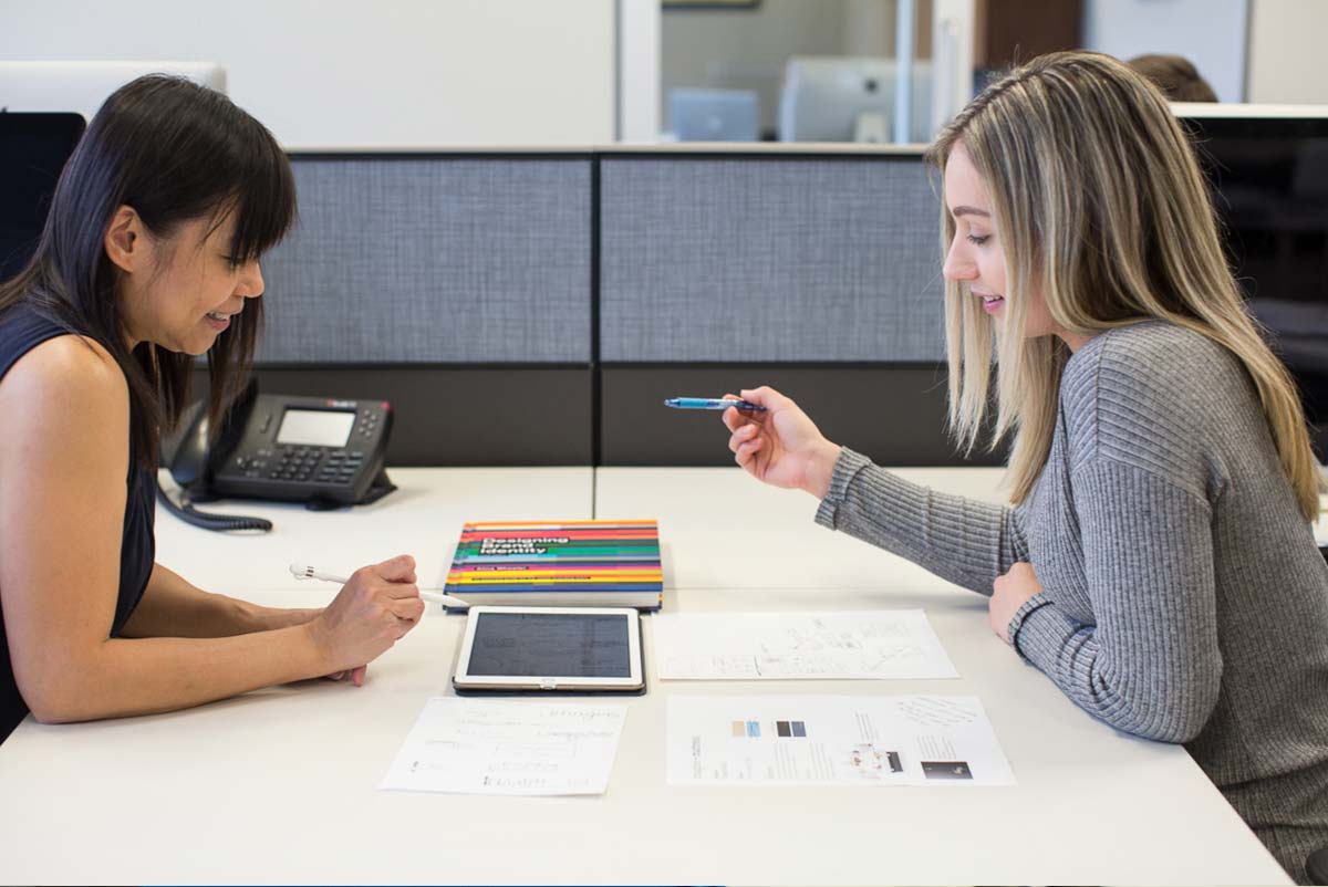 The Loft designers Chrissy and Ling reviewing branding materials together