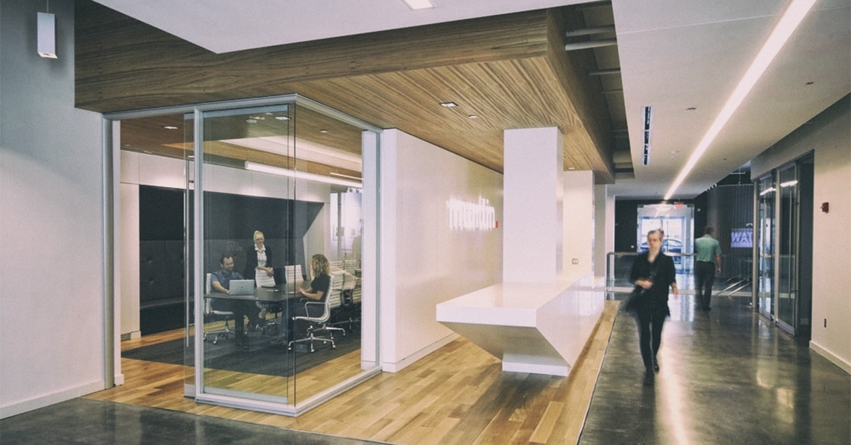 Interior of The Martin Group's Buffalo headquarters with glass meeting room and wood finishes