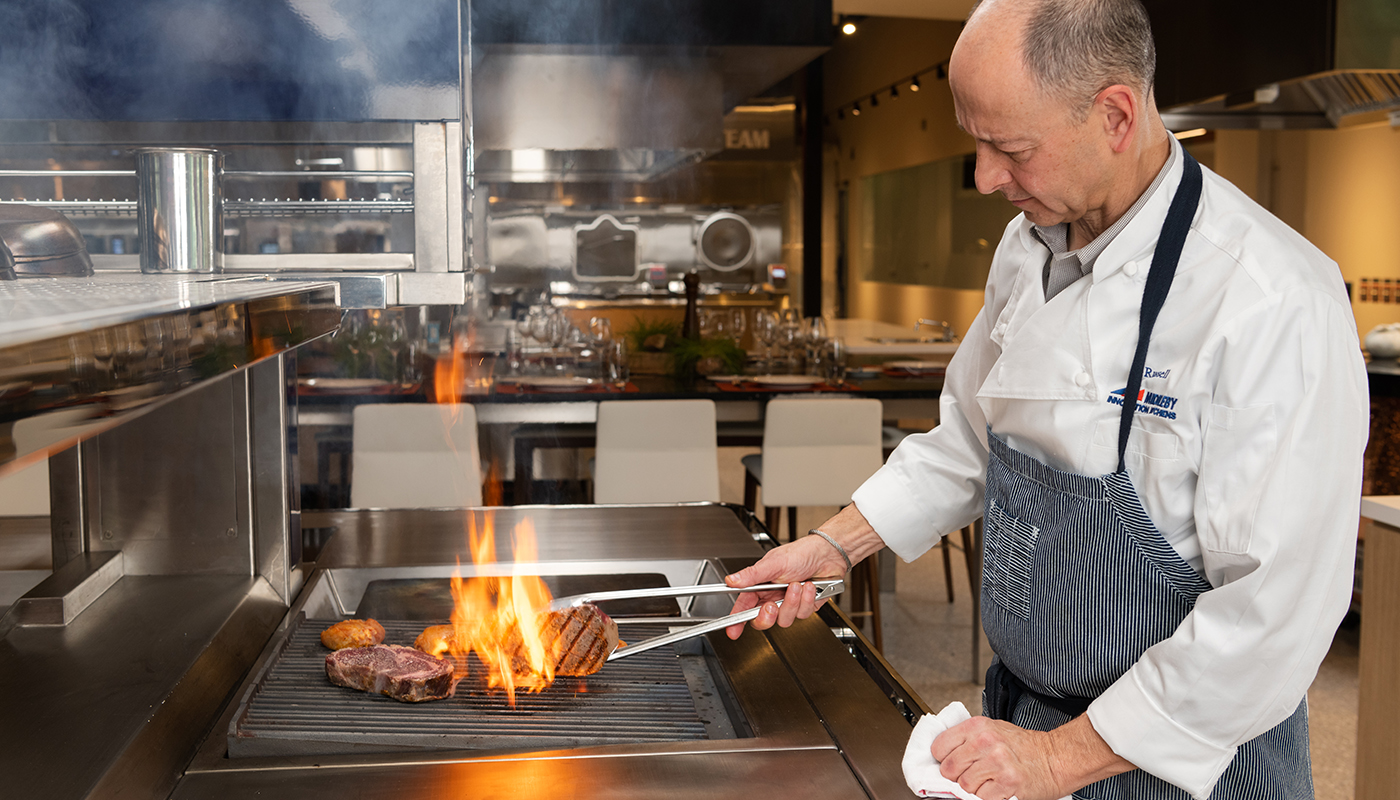 Chef Russell Scott cooking over a grill at Middleby Innovation Kitchens