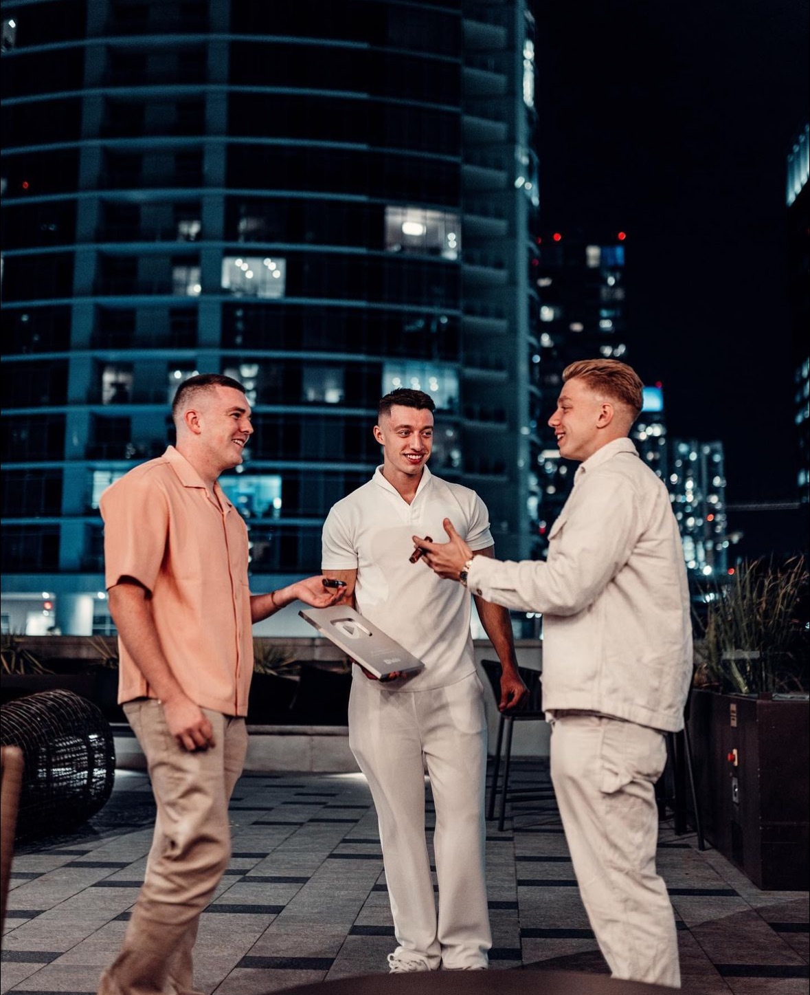 The three School of Hard Knocks founders together outdoors, one holding a YouTube creator award