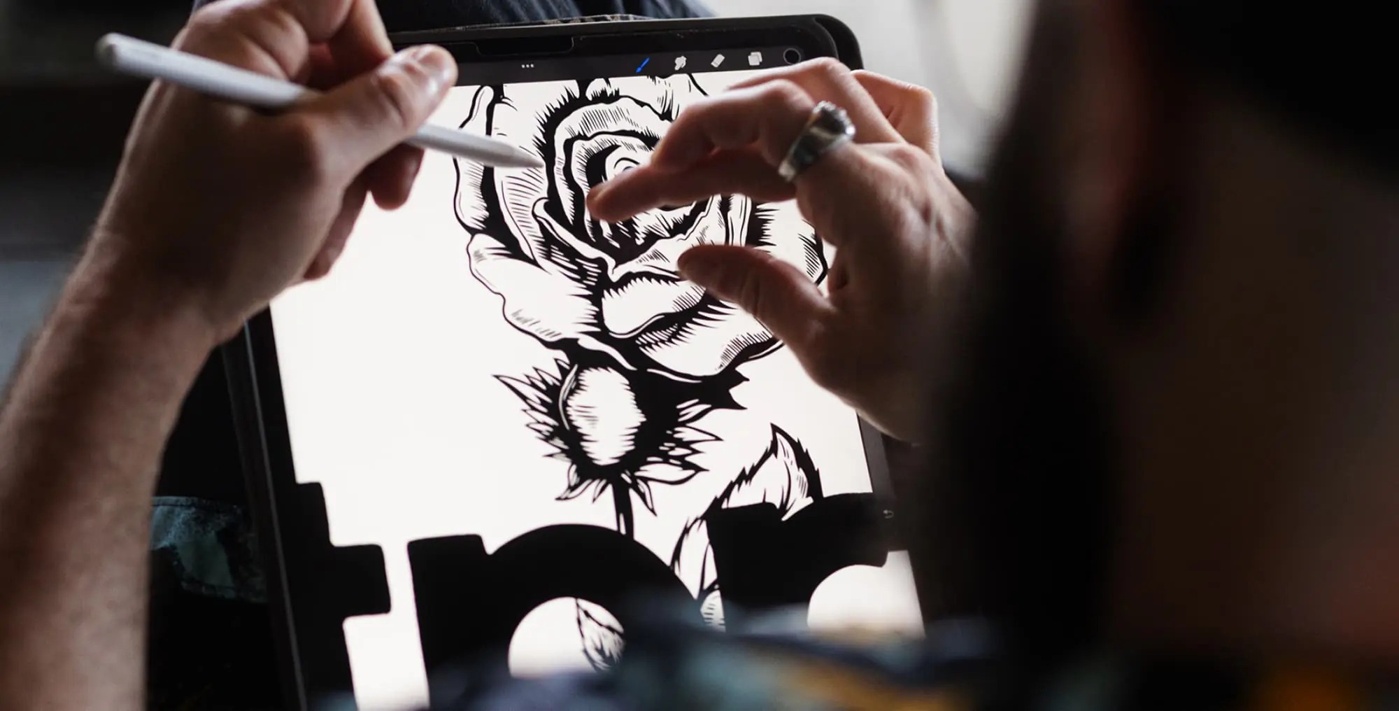 An illustrator works on a detailed rose drawing on a tablet at The Taproot Agency