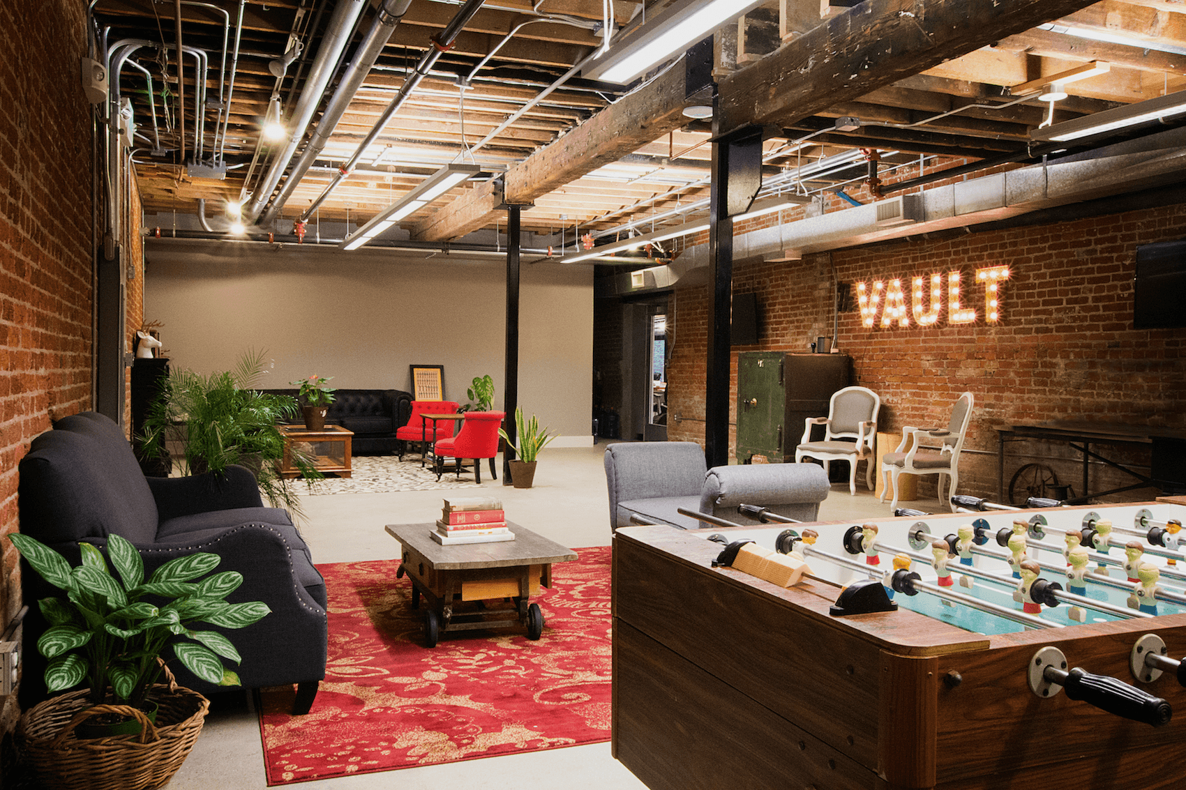 The Vault’s historical Jackson Square lounge, with exposed beams, armchairs and a foosball table