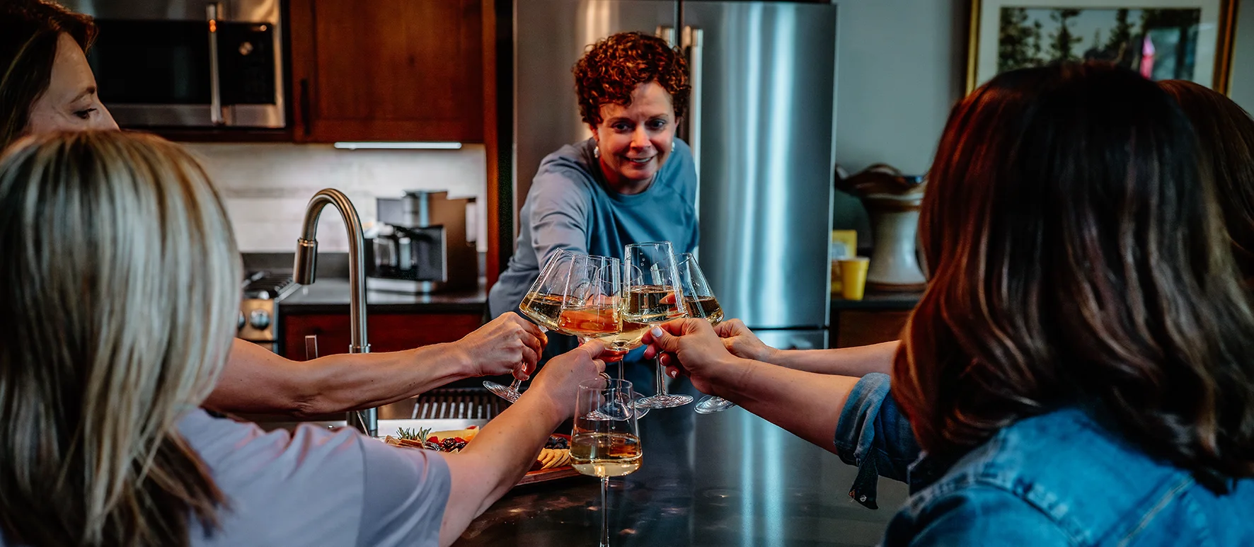 Brenda Peterson and Wendt colleagues raising wine glasses in a kitchen