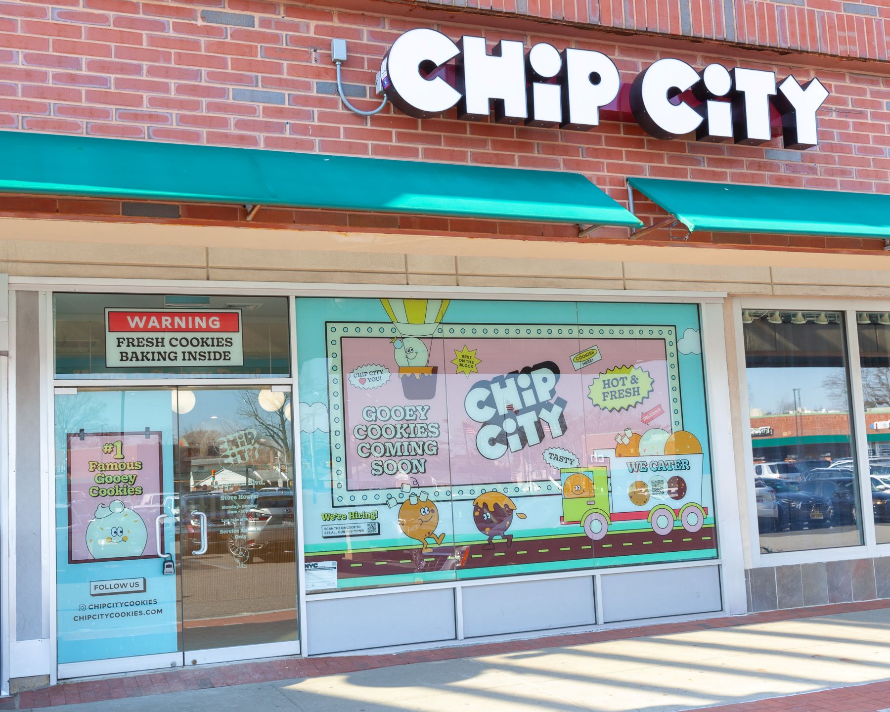 A Chip City storefront with turquoise awnings and playful illustrated window graphics