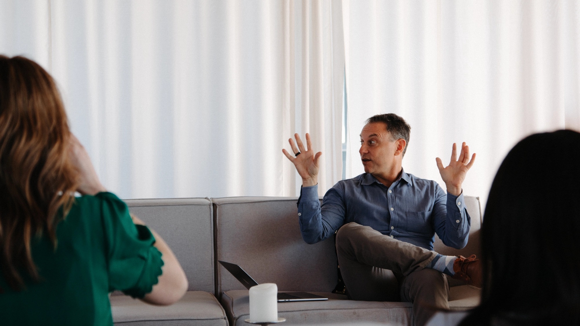 A thinkPARALLAX team conversation, with a colleague gesturing from a sofa