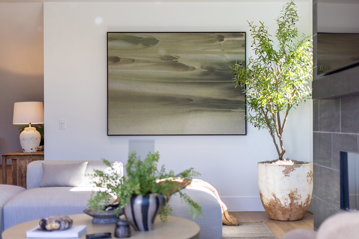 Living room at 915 Kagawa Street with cream seating, a potted tree and framed artwork