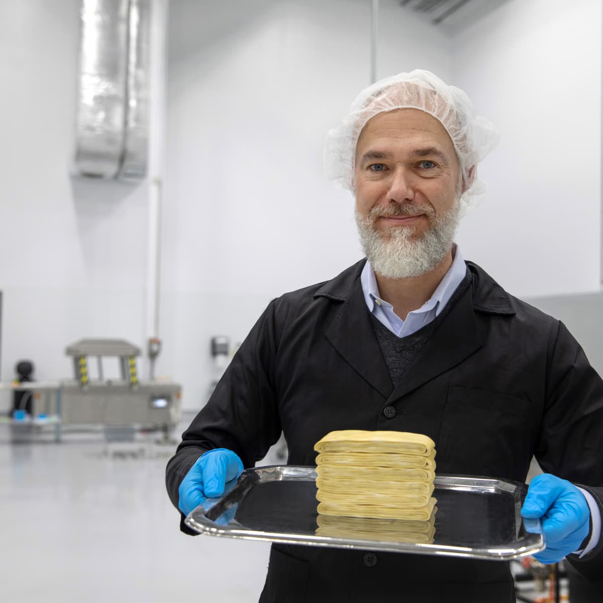 Thomas Jonas in protective clothing holding a tray of Fy protein inside Nature's Fynd production facility