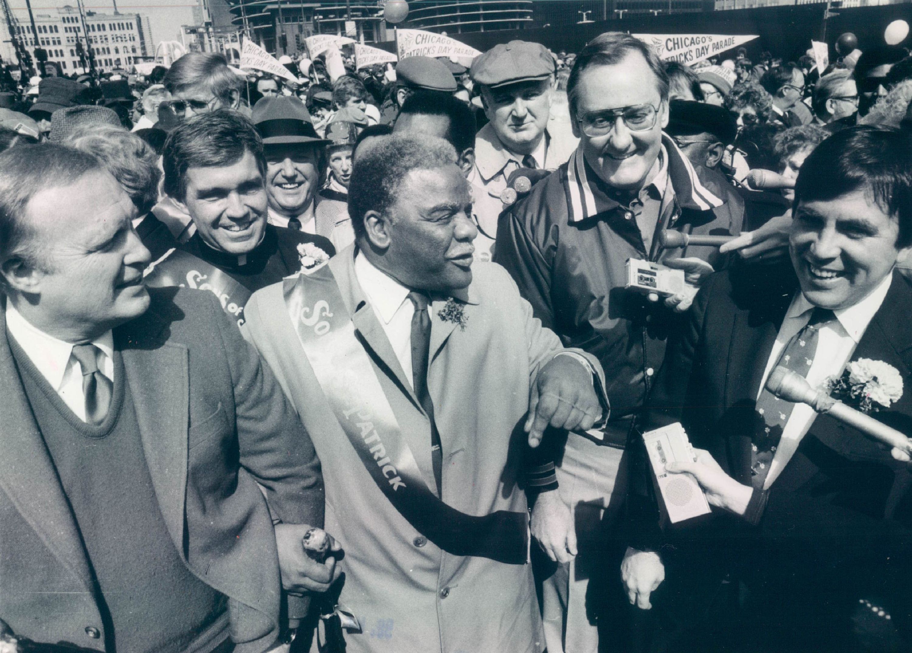 Thomas Coffey at right beside Mayor Harold Washington during a Chicago St. Patrick’s Day parade, with Governor Jim Thompson behind them.