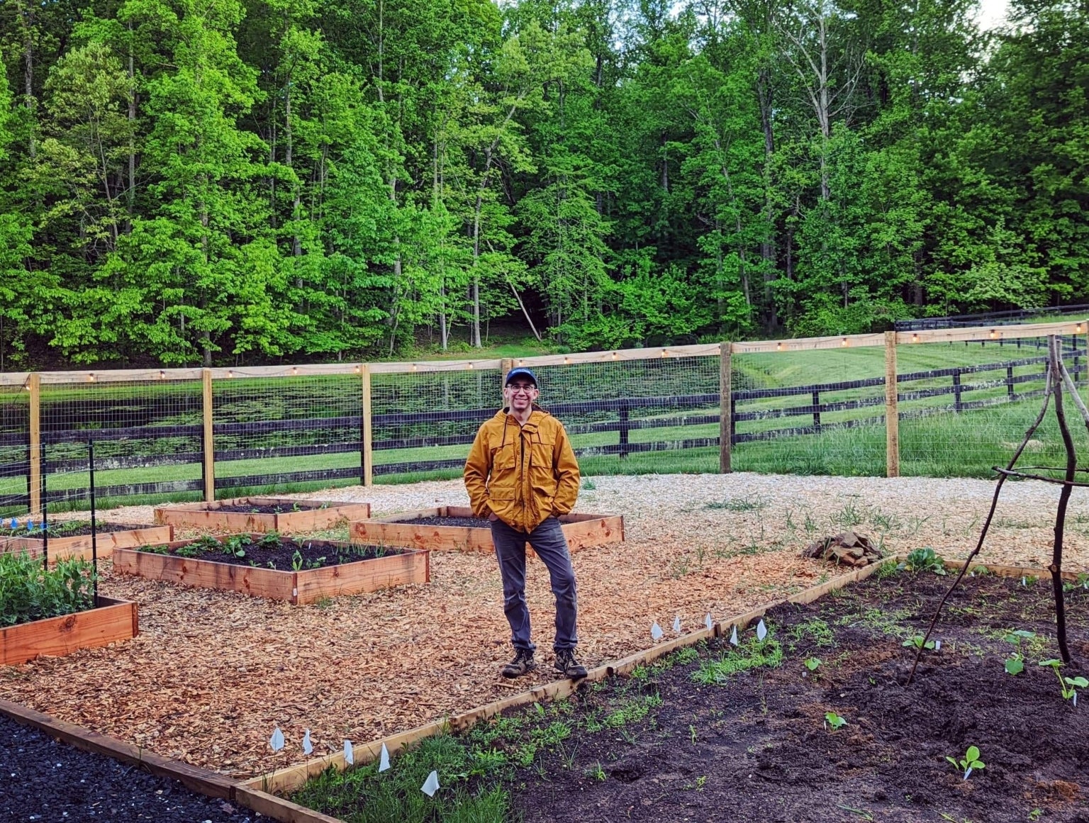 Thomas Sanchez standing among raised vegetable beds on a Virginia farm