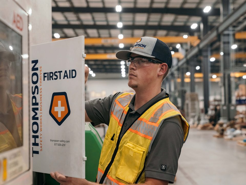 A Thompson Safety technician checking a first-aid cabinet in a warehouse