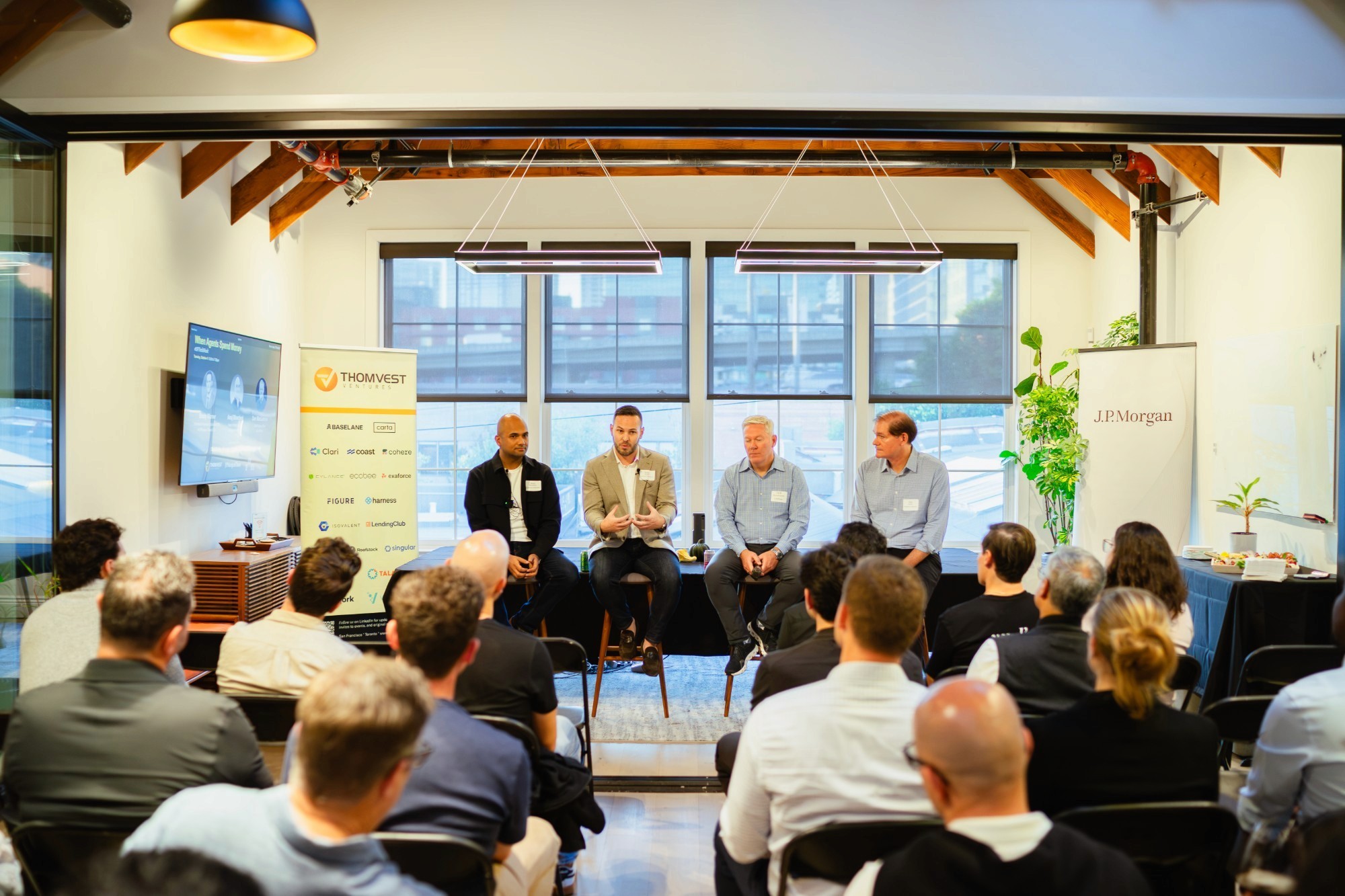 Four panelists speak to an audience at a Thomvest event in San Francisco